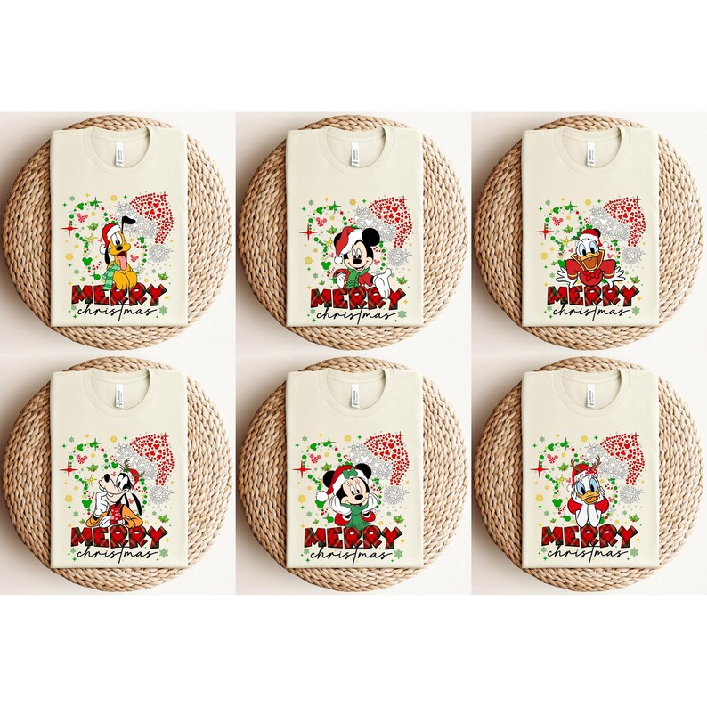 May include: Six cream-colored t-shirts with Christmas-themed designs featuring Disney characters. Each shirt displays a different character, including Mickey Mouse, Pluto, and Donald Duck, wearing Santa hats. The text "MERRY CHRISTMAS" is printed below each character.