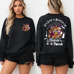 May include: Black sweatshirt with a white graphic print of Mickey Mouse and friends dressed as witches. The text "It's just a bunch of Hocus Pocus" is printed on the back of the sweatshirt.