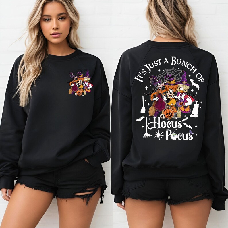 May include: Black sweatshirt with a white graphic print of Mickey Mouse and friends dressed as witches. The text "It's just a bunch of Hocus Pocus" is printed on the back of the sweatshirt.