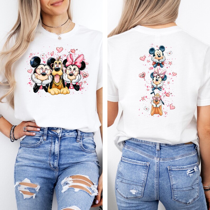 May include: White t-shirt featuring a colorful graphic of Mickey Mouse, Minnie Mouse, and Pluto. The front design shows the characters together, while the back has a vertical arrangement of the characters with hearts and stars.