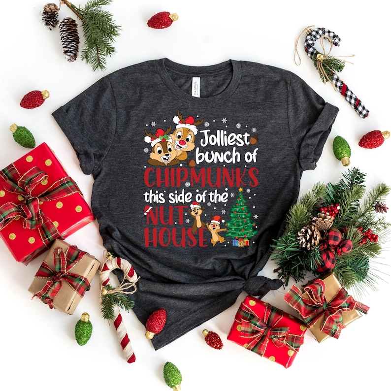 May include: A dark gray t-shirt with a Christmas-themed design featuring two cartoon chipmunks wearing Santa hats and the text "Jolliest bunch of Chipmunks this side of the Nut House".
