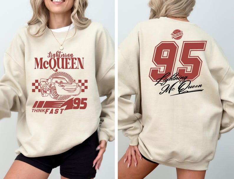 May include: A beige sweatshirt with a red graphic of Lightning McQueen from the Cars movie. The graphic includes the text "Lightning McQueen", "Think Fast", and "95". The back of the sweatshirt has a red number "95" with the text "Lightning McQueen" in black.