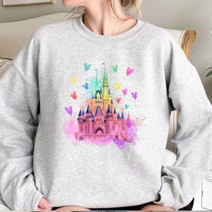 May include: A gray sweatshirt with a watercolor illustration of Cinderella's castle with rainbow Mickey Mouse balloons.