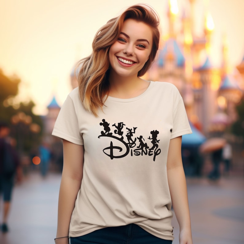 May include: A white t-shirt with a black graphic of Mickey Mouse and other Disney characters. The graphic includes the word "DISNEY" in a stylized font.