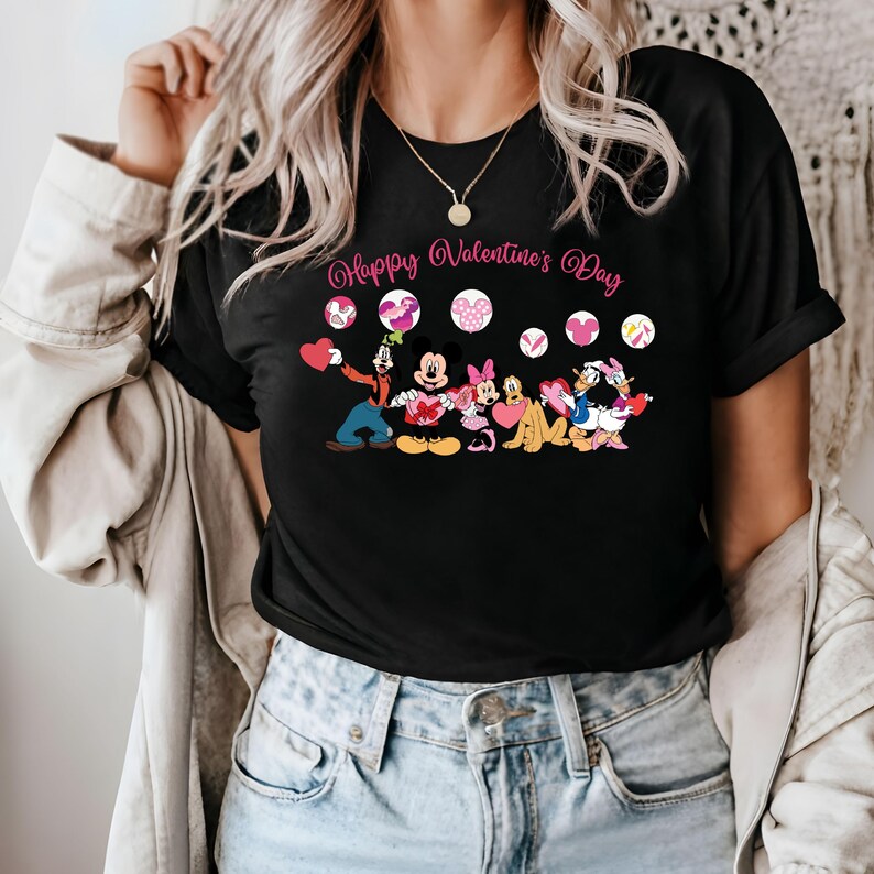 May include: Black t-shirt with a graphic of Mickey Mouse, Minnie Mouse, Donald Duck, Goofy, and Pluto holding hearts. The text "Happy Valentine's Day" is printed above the characters.