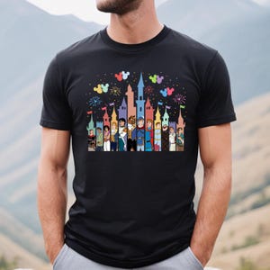 Puede incluir: Una camiseta negra con una ilustraci&oacute;n colorida de un castillo y personajes de Disney. El castillo est&aacute; rodeado de fuegos artificiales y globos de Mickey Mouse.