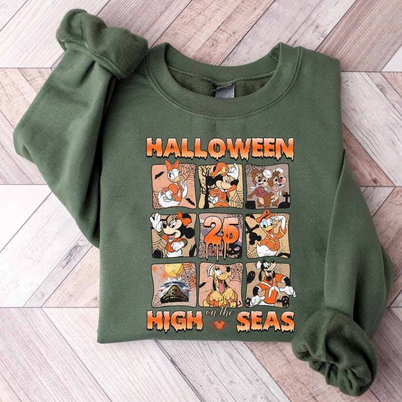 May include: Green sweatshirt with a graphic print of Mickey Mouse and other Disney characters. The text "HALLOWEEN on the HIGH SEAS" is printed on the front of the sweatshirt.