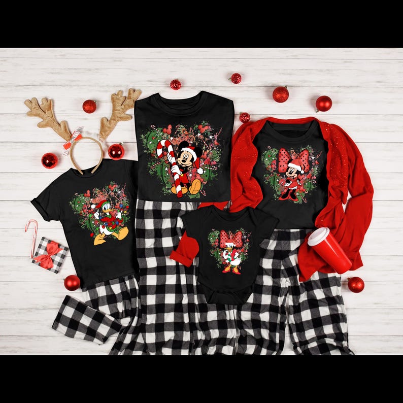 May include: A family of four matching Christmas pajamas with black and white plaid pants. The shirts feature a festive green and red design with Mickey Mouse, Minnie Mouse, and Donald Duck.