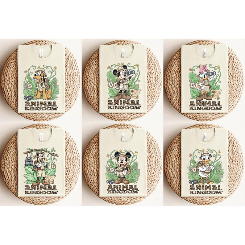May include: Six cream-colored t-shirts featuring Disney characters in safari outfits. Each shirt has a different character: Pluto, Mickey Mouse, Daisy Duck, Goofy, and Donald Duck. The text "ANIMAL KINGDOM" is printed at the bottom of each shirt.