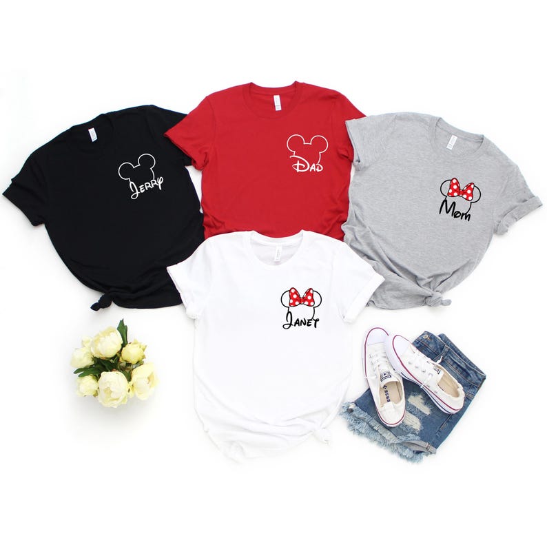 May include: Four t-shirts in black, red, white, and gray, each with a Disney-themed design. The black shirt says "Jerry", the red shirt says "Dad", the white shirt says "Janet", and the gray shirt says "Mom".