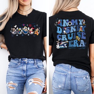 May include: Black t-shirt with a graphic of Mickey Mouse and friends on a cruise ship. The back of the shirt says "In My Disney Cruise Era" in blue and white letters.