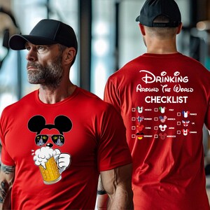 Puede incluir: Camiseta roja con un dibujo animado de Mickey Mouse bebiendo una cerveza. La parte posterior de la camiseta tiene una lista de verificaci&oacute;n con el texto "Drinking Around the World" y una lista de pa&iacute;ses con casillas de verificaci&oacute;n.