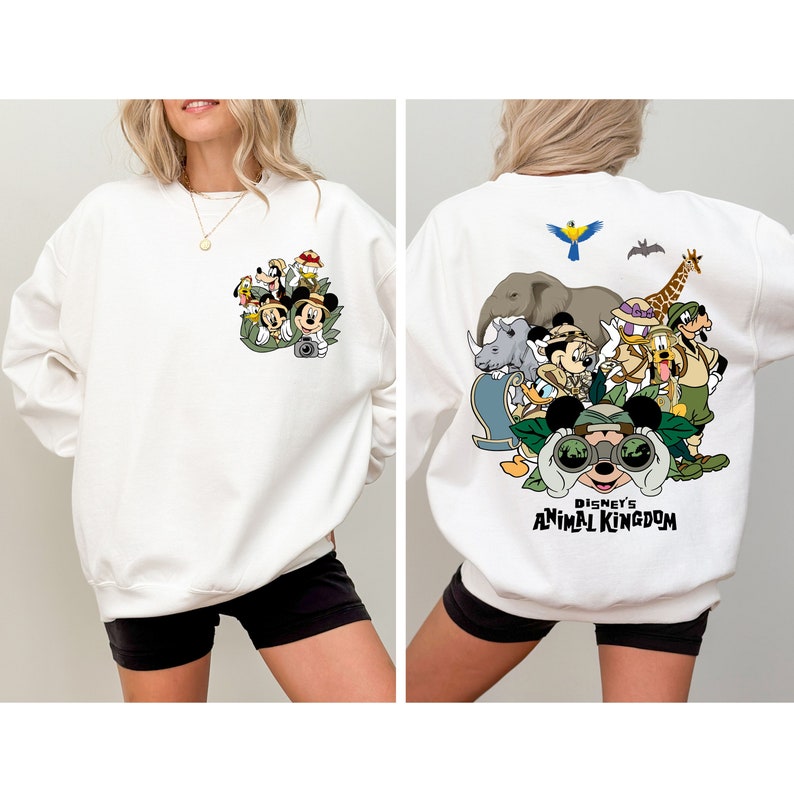 May include: White sweatshirt with a graphic print of Mickey Mouse and friends in safari gear on the front and a larger graphic print of Mickey Mouse and friends in safari gear with the text "Disney's Animal Kingdom" on the back.