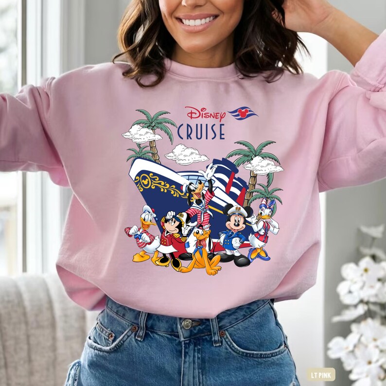 Pu&ograve; includere: Felpa rosa con una grafica di Topolino e i suoi amici su una nave da crociera Disney. Il testo "Disney Cruise" &egrave; stampato sulla maglietta.