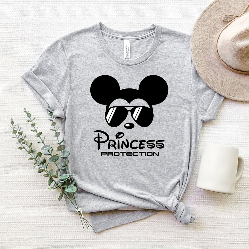 May include: Gray t-shirt with a black and white illustration of Mickey Mouse wearing sunglasses. The text "Princess Protection" is printed below the image.