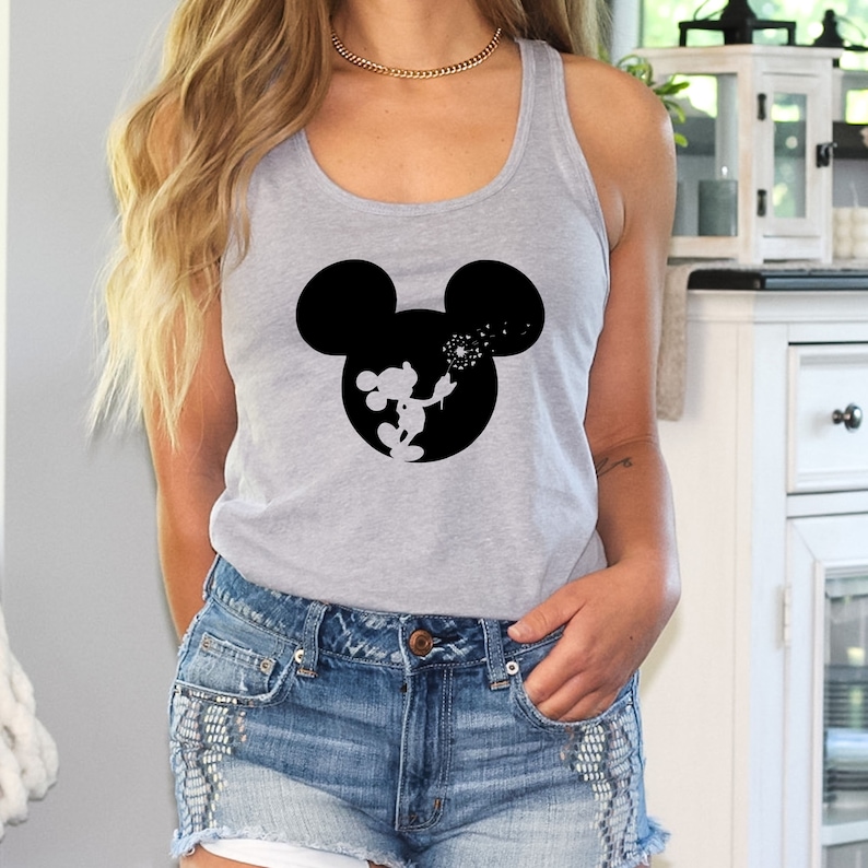 May include: A gray tank top with a black silhouette of Mickey Mouse blowing dandelions. The tank top is being worn by a person with long blonde hair.