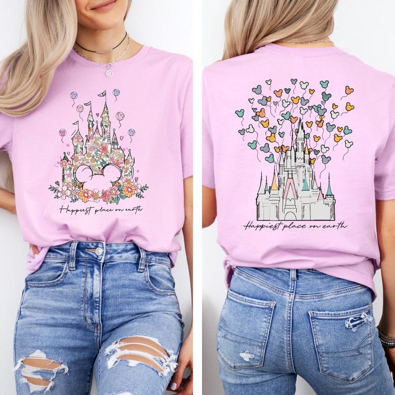 May include: A pink t-shirt with a floral design of a castle and the text "Happiest place on earth". The back of the shirt has a castle with Mickey Mouse balloons.