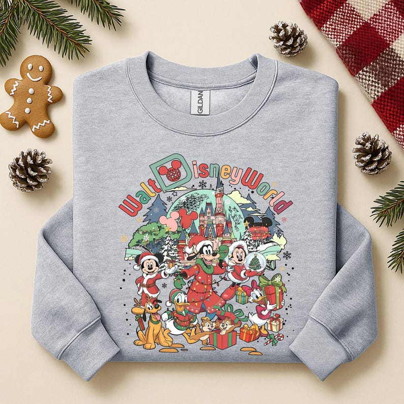 May include: A light gray sweatshirt featuring a colorful graphic of Disney characters in holiday attire. The graphic includes Mickey Mouse, Minnie Mouse, Donald Duck, and others, with the words "Walt Disney World" in a festive font.