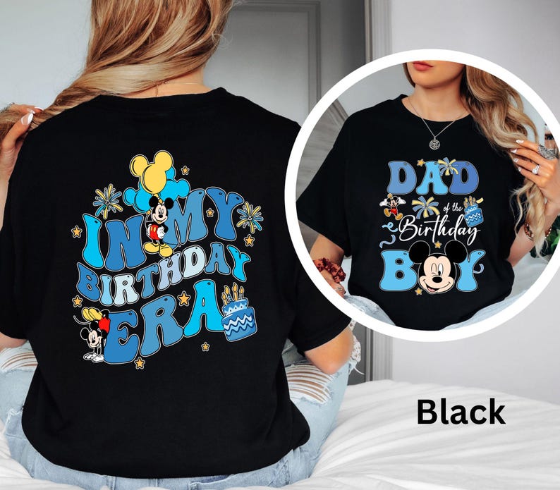Op de afbeelding: Zwarte T-shirts met Mickey Mouse-ontwerpen. E&eacute;n shirt zegt "IN MY BIRTHDAY ERA" met Mickey Mouse en verjaardagstaartafbeeldingen. De andere zegt "DAD of the Birthday BOY" met Mickey Mouse-afbeeldingen.