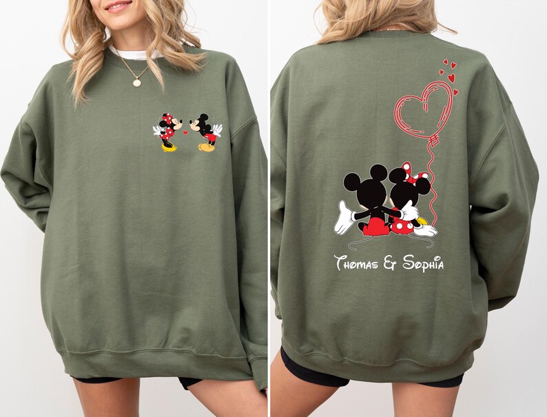 May include: A green sweatshirt with a Mickey Mouse and Minnie Mouse graphic on the front and a Mickey Mouse and Minnie Mouse graphic with a heart and the text "Thomas & Sophia" on the back.