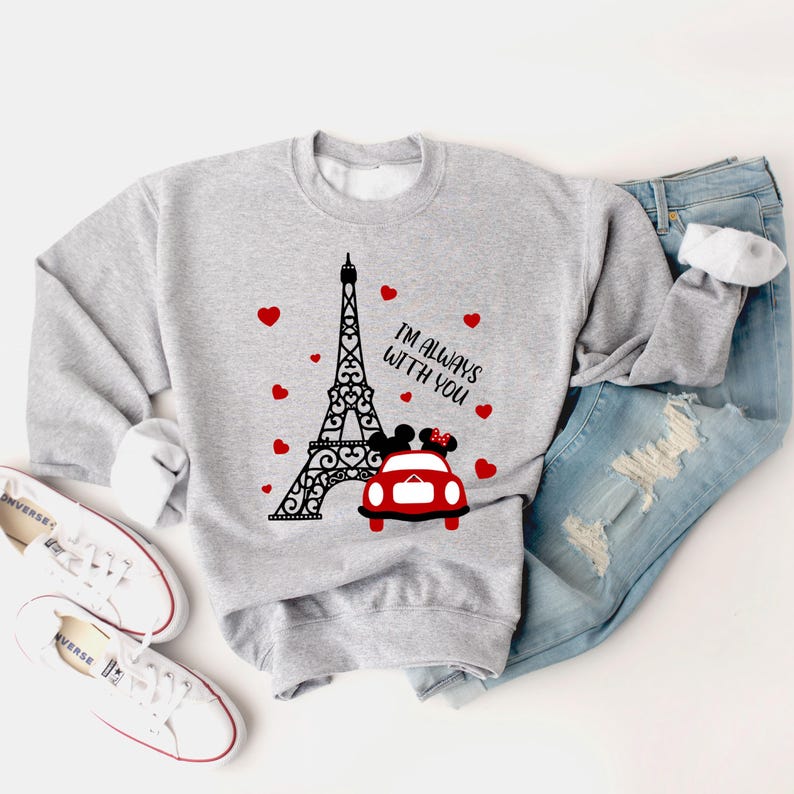 May include: Gray sweatshirt with a black and white illustration of the Eiffel Tower, a red car with Mickey and Minnie Mouse inside, and the text "I'm always with you". There are red hearts scattered around the design.