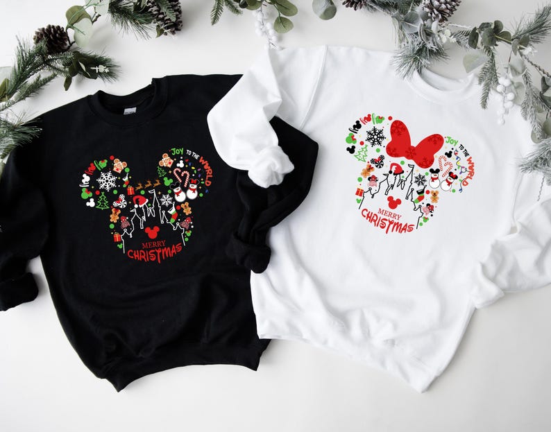 Pu&ograve; includere: Felpe nere e bianche con un design a forma di Mickey Mouse pieno di grafiche a tema natalizio. Il design include fiocchi di neve, omini di pan di zenzero e il testo "Merry Christmas" e "Joy to the World".