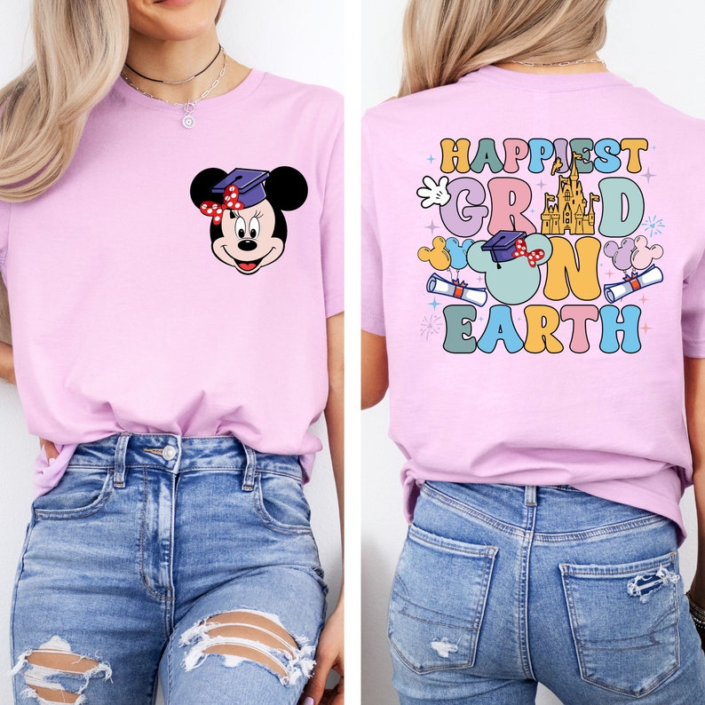 Puede incluir: Camiseta rosa con un gr&aacute;fico de Mickey Mouse con un gorro de graduaci&oacute;n y el texto "Happiest Grad on Earth" en la parte posterior.
