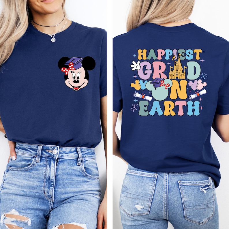 Puede incluir: Una camiseta azul marino con un gr&aacute;fico de Mickey Mouse en la parte delantera y el texto "Happiest Grad on Earth" en la parte posterior. La camiseta presenta un dise&ntilde;o colorido con un castillo, gorros de graduaci&oacute;n y orejas de Mickey Mouse.
