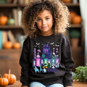 Puede incluir: Sudadera negra con un gr&aacute;fico colorido de la Mansi&oacute;n Encantada de la atracci&oacute;n Haunted Mansion de Disney. El gr&aacute;fico incluye el texto "Haunted Mansion".