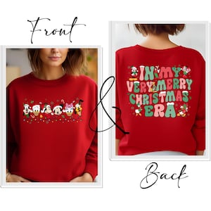 May include: Red Christmas sweatshirt with a line of Disney characters on the front and the text "In My Very Merry Christmas Era" on the back.
