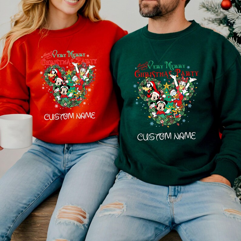 Może przedstawiać: Czerwone i zielone świąteczne swetry z wzorem Myszki Miki z udziałem Myszki Miki, Minnie, Donalda, Goofy'ego i Pluto. Swetry mają napis "Very Merry Christmas Party" i "Custom Name".