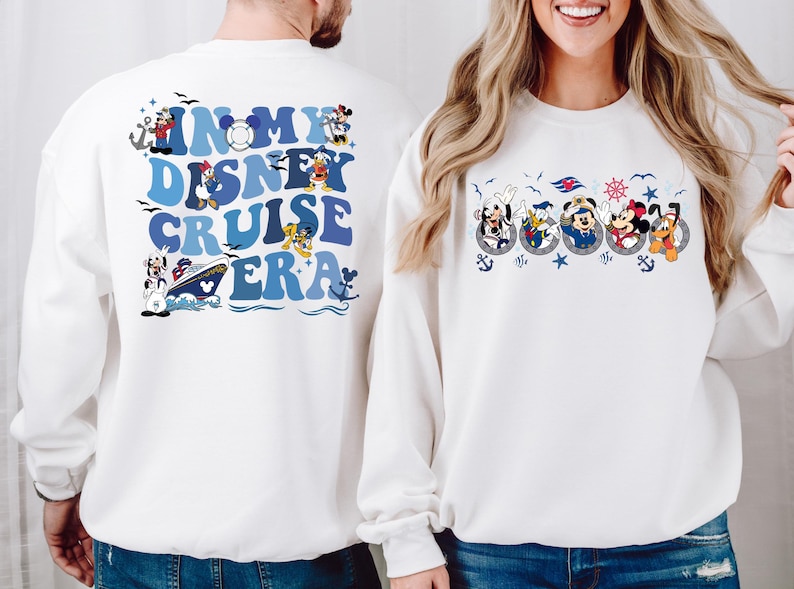 May include: White sweatshirts with a Disney Cruise themed design. One sweatshirt has the text "In My Disney Cruise Era" with a cruise ship and Disney characters. The other sweatshirt has a row of Disney characters in life preservers.