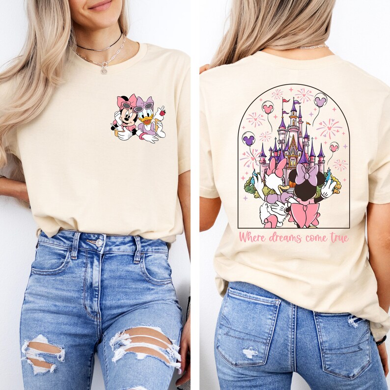 Pu&ograve; includere: Una maglietta beige chiaro con un'immagine di Topolino e Minnie Mouse sul davanti e un'immagine del castello di Cenerentola con fuochi d'artificio e il testo "Where dreams come true" sul retro.