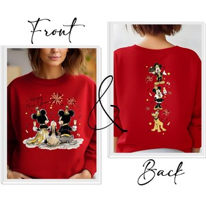Puede incluir: Sudadera roja con un dise&ntilde;o frontal de Mickey y Minnie Mouse brindando con champ&aacute;n, con el texto "Happy New Year". La parte trasera presenta un dise&ntilde;o vertical de Mickey, Minnie y Pluto. Dise&ntilde;o festivo.