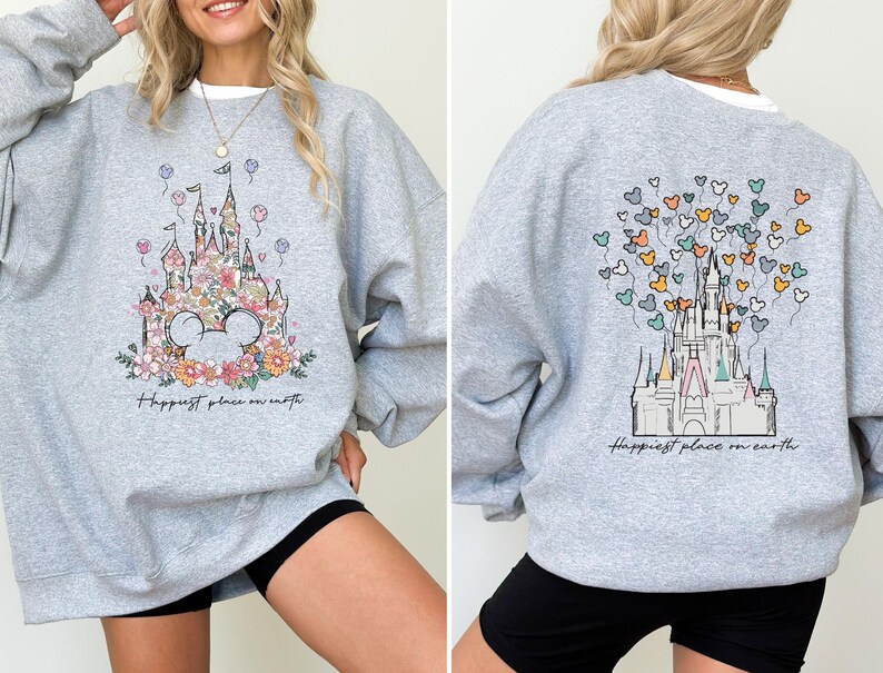 May include: A gray sweatshirt with a floral print of Cinderella's castle and the text "Happiest place on earth".