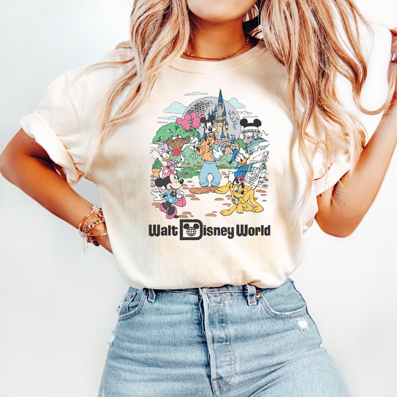 May include: A white t-shirt with a vintage-style graphic of Mickey Mouse and other Disney characters in front of Cinderella's Castle. The text "Walt Disney World" is printed below the graphic.