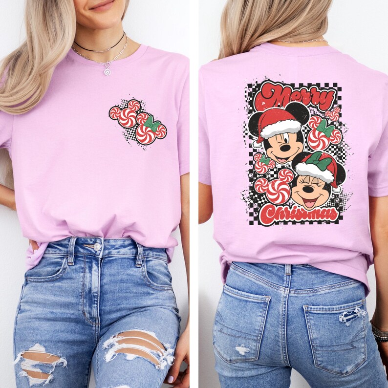 May include: A light pink t-shirt featuring a Christmas design. The front of the shirt has a candy cane graphic. The back of the shirt has a graphic of Mickey and Minnie Mouse wearing Santa hats, with the words "Merry Christmas".