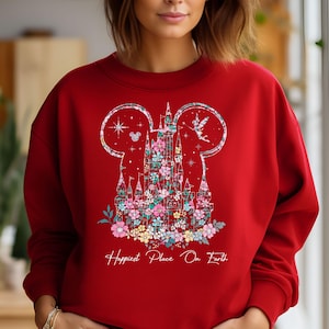 May include: Red sweatshirt with a floral design of Cinderella's castle in the shape of Mickey Mouse ears. The text "Happiest Place On Earth" is printed below the design.