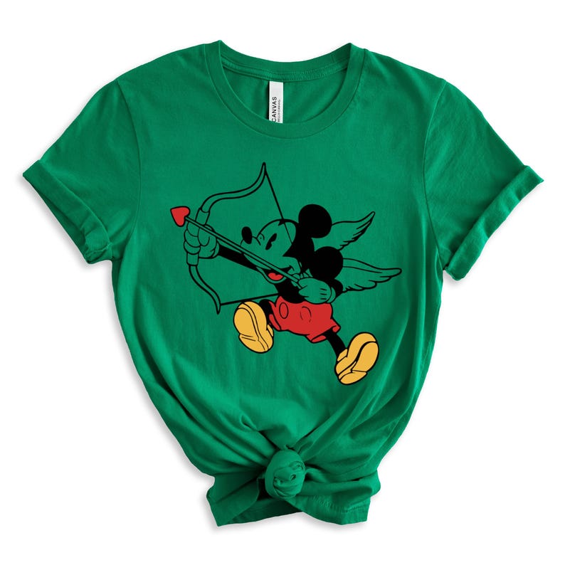 May include: Green t-shirt featuring a cartoon image of Mickey Mouse dressed as Cupid, holding a bow and arrow with a heart on the arrowhead.