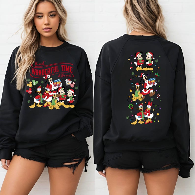 May include: Black sweatshirt featuring a festive design with Disney characters in Santa hats. The front displays Mickey, Donald, and Goofy with text that reads "The most wonderful time of the year." The back shows a vertical arrangement of the characters.