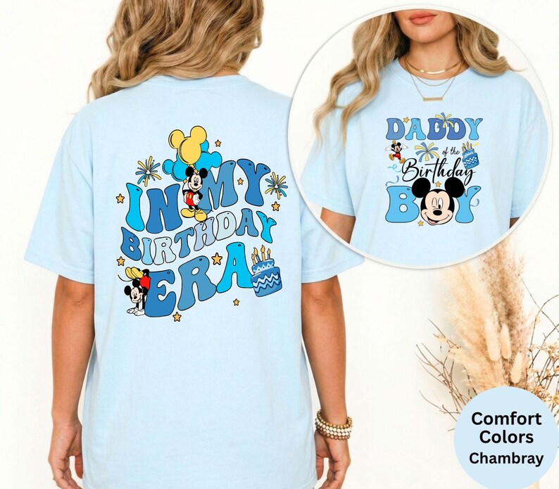 Op de afbeelding: Lichtblauw T-shirt met de tekst "IN MY BIRTHDAY ERA" en Mickey Mouse-afbeeldingen op de rug. De voorkant toont "DADDY of the Birthday BOY" en een Mickey Mouse-afbeelding. Het shirt is een comfort color chambray.