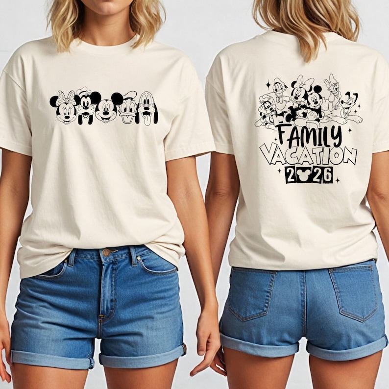 May include: Cream-colored t-shirt featuring a black and white graphic of Disney characters on the front and back. The front displays Minnie Mouse, Mickey Mouse, Goofy, and Pluto. The back says "Family Vacation 2026."