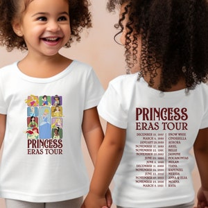 以下が含まれることがあります： ディズニーのプリンセスが描かれた白いTシャツ2枚。1枚のシャツの前には、プリンセスのコラージュと「プリンセス・エラス・ツアー」の文字が書かれている。もう1枚のシャツの後ろには、プリンセスのリストとリリース日が「プリンセス・エラス・ツアー」の文字と共に書かれている。