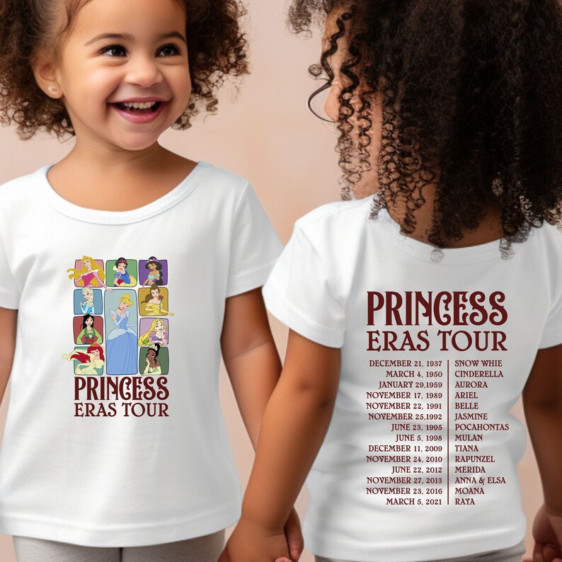 以下が含まれることがあります： ディズニーのプリンセスが描かれた白いTシャツ2枚。1枚のシャツの前には、プリンセスのコラージュと「プリンセス・エラス・ツアー」の文字が書かれている。もう1枚のシャツの後ろには、プリンセスのリストとリリース日が「プリンセス・エラス・ツアー」の文字と共に書かれている。