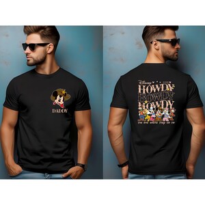 May include: Black t-shirt featuring a cartoon Mickey Mouse wearing a cowboy hat with the word "DADDY" below. The back of the shirt displays "Howdy" text and Disney characters.