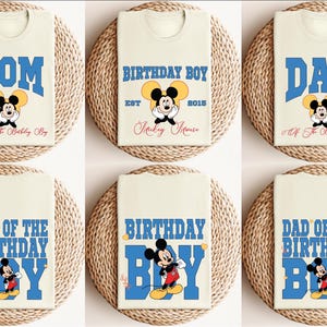 Puede incluir: Seis camisetas de color crema con dise&ntilde;os de Mickey Mouse azules y amarillos. Las camisetas muestran el texto "Mom", "Dad", "Birthday Boy", "Mom of the Birthday Boy", "Dad of the Birthday Boy" y "Birthday Boy".