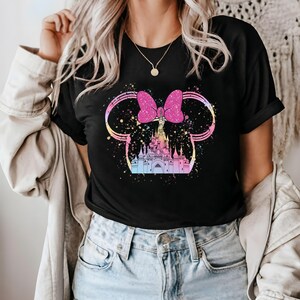 May include: Black t-shirt with a pink bow and a colorful illustration of a castle. The castle is surrounded by a sparkly design.