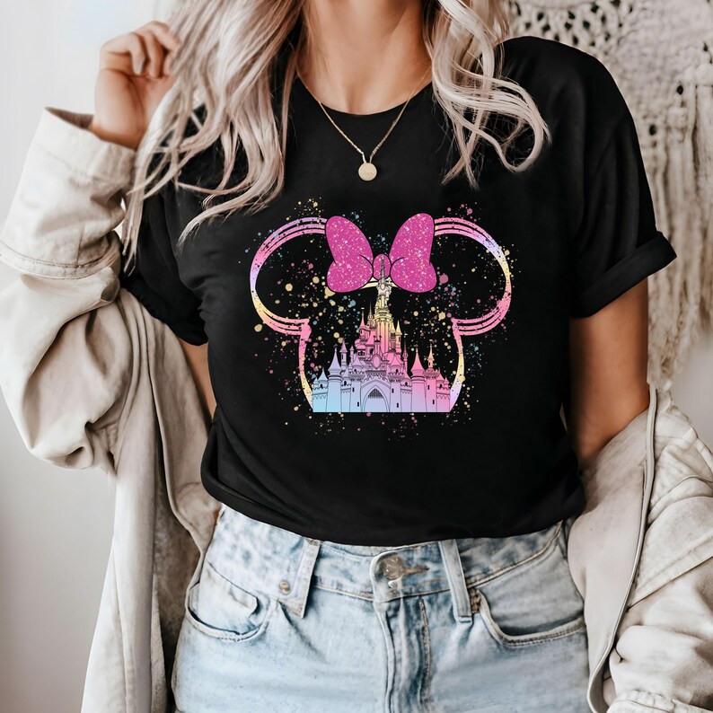 May include: Black t-shirt with a pink bow and a colorful illustration of a castle. The castle is surrounded by a sparkly design.