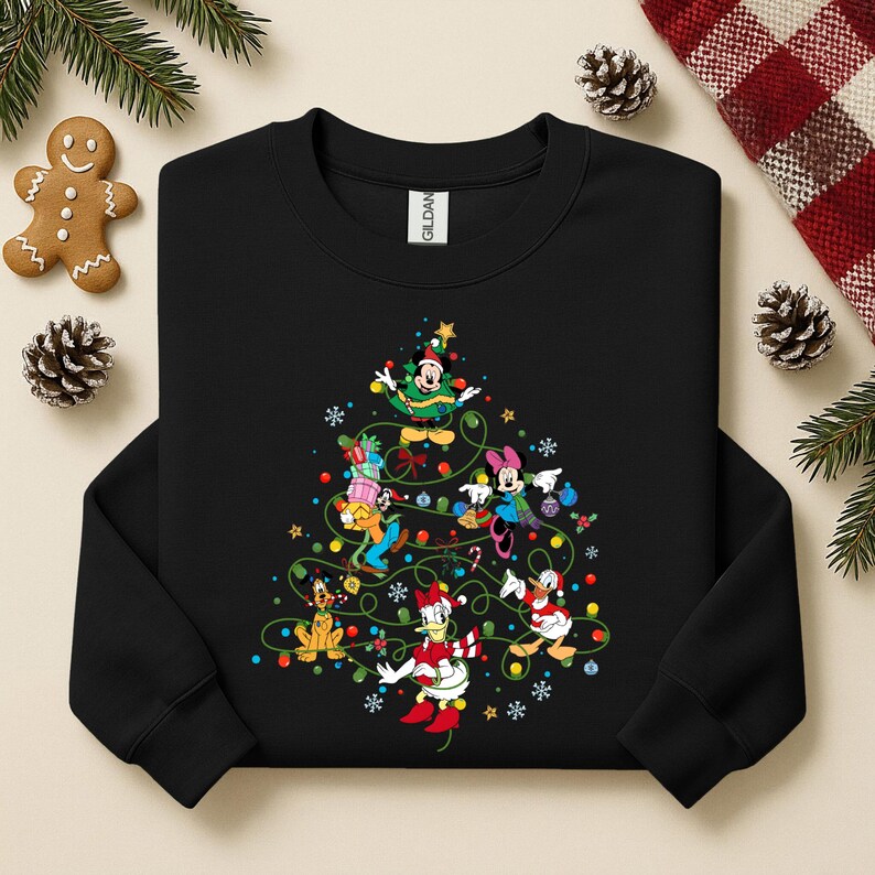 K&ouml;nnte beinhalten: Schwarzes Sweatshirt mit Rundhalsausschnitt und einem Weihnachtsbaumdesign mit Disney-Figuren. Der Baum ist mit bunten Lichtern, Kugeln und Sternen geschm&uuml;ckt. Micky Maus, Minnie Maus, Donald Duck und Goofy geh&ouml;ren zu den Figuren.