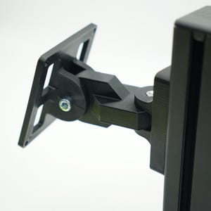 May include: A black metal TV wall mount with a swivel arm and a rectangular base plate. The mount is designed to attach to a wall and hold a TV.